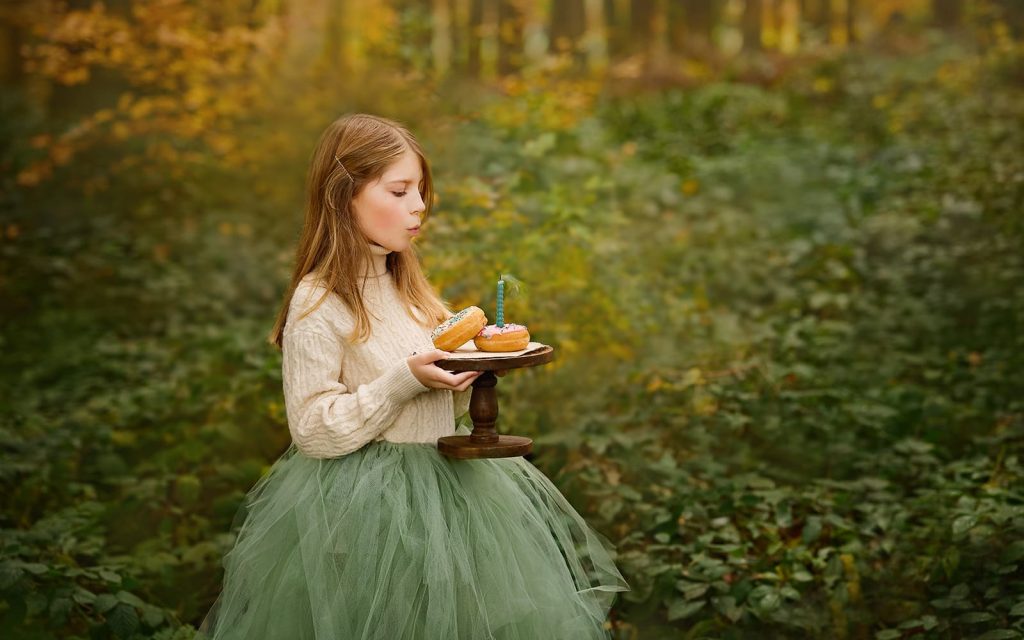 Geburtstag Mädchen Foto im Wald. Herbst Farbe und natürlichem Licht. Donuts und Kerze. Kanton Luzern.